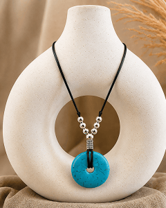 Turquoise Donut Necklace displayed on a modern pottery vase.